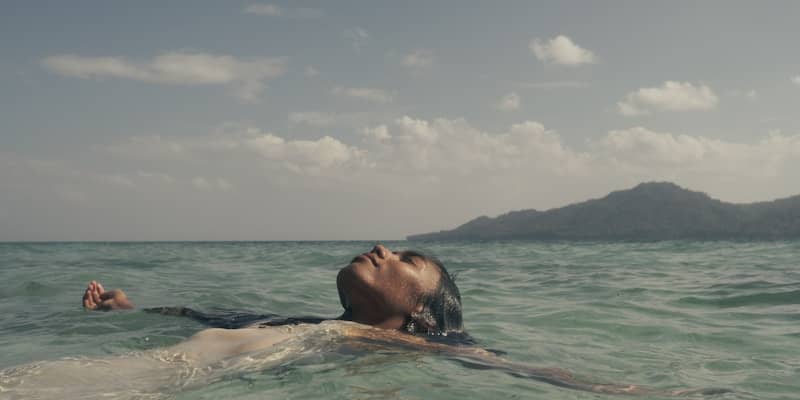 A man floating in the ocean with his head above the water