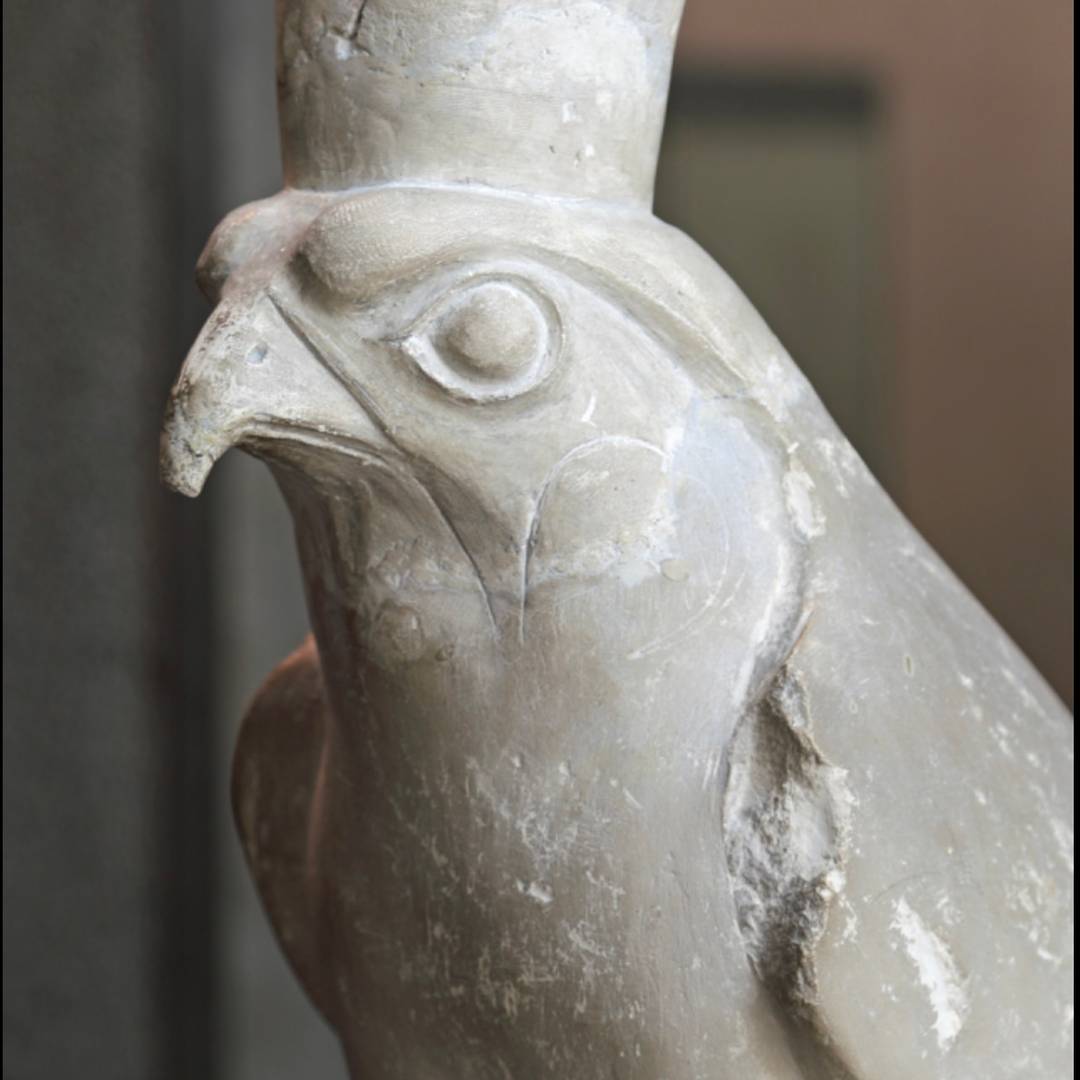 whitish stone statuette of Horus as a falcon with crown.
