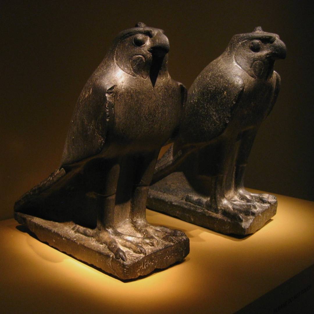 ancient Egyptian Horus a falcons pair of bronze statues in the spotlight.