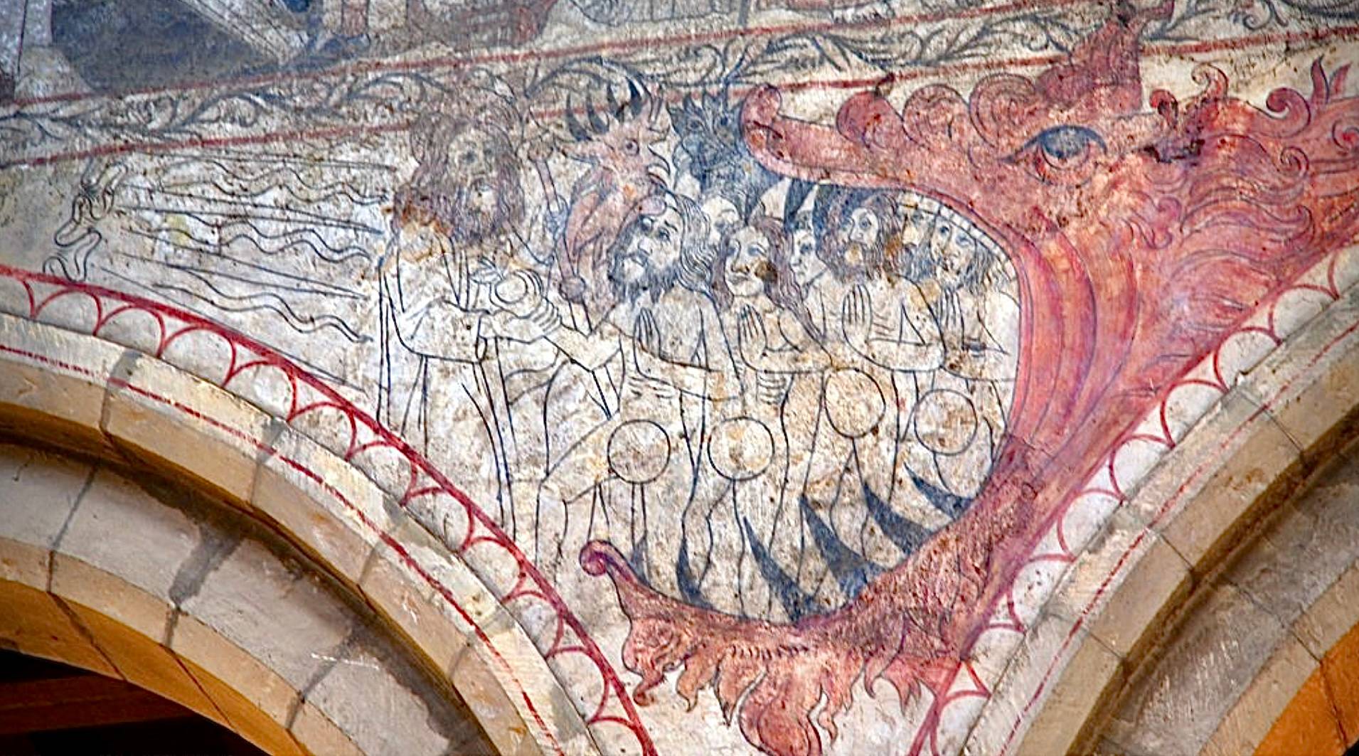 Medieval church wall painting of sinners in the jaws of a red dragon or devil.