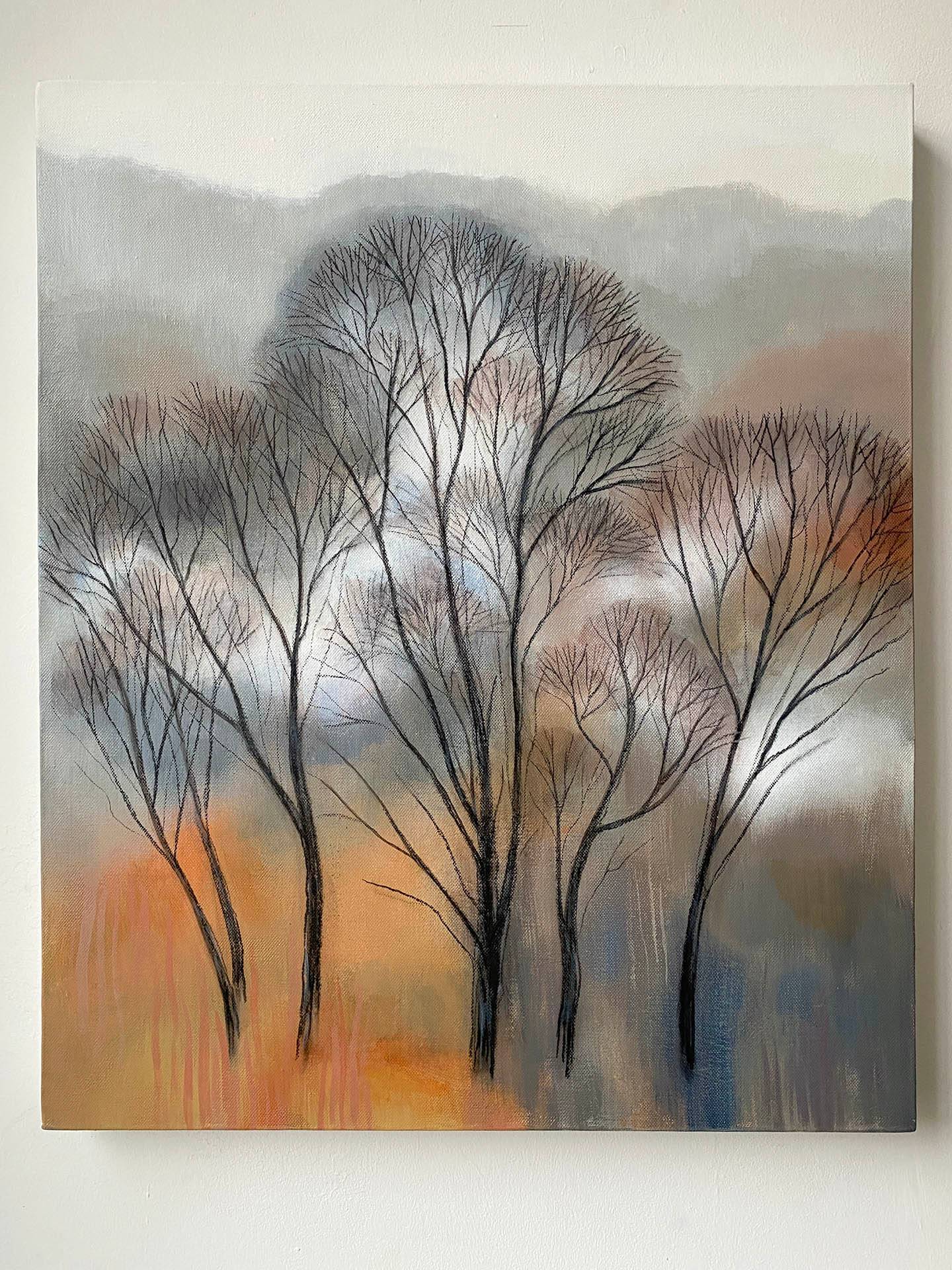 Winter trees in black against russet and grey hillside with mist weaving through branches.