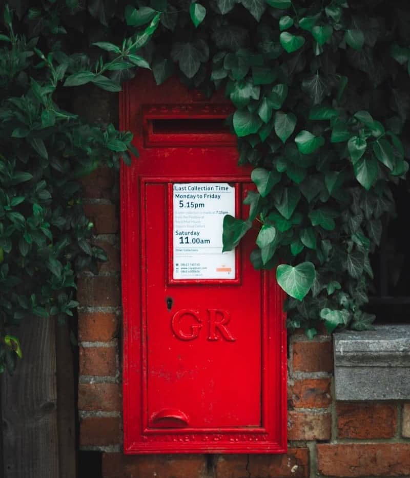 red mail box on brown brick wall