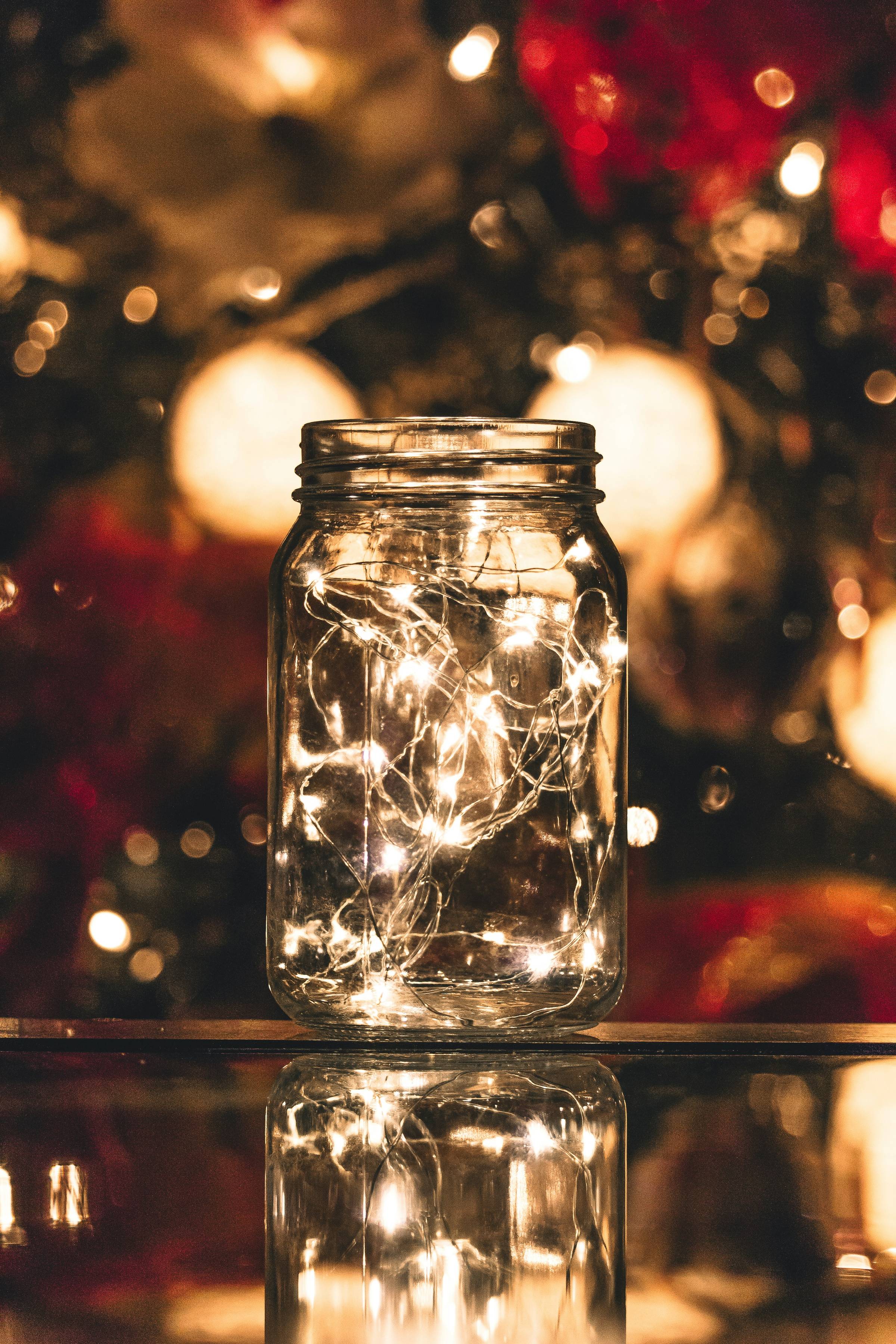 fairy lights in a mason jar in front of a blurred image of decorations
