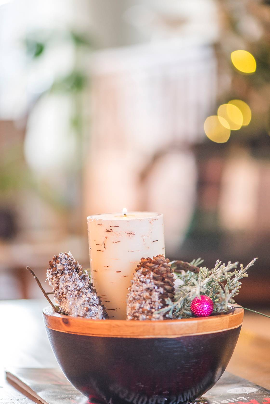A cozy candle with on a table for Christmas decorations