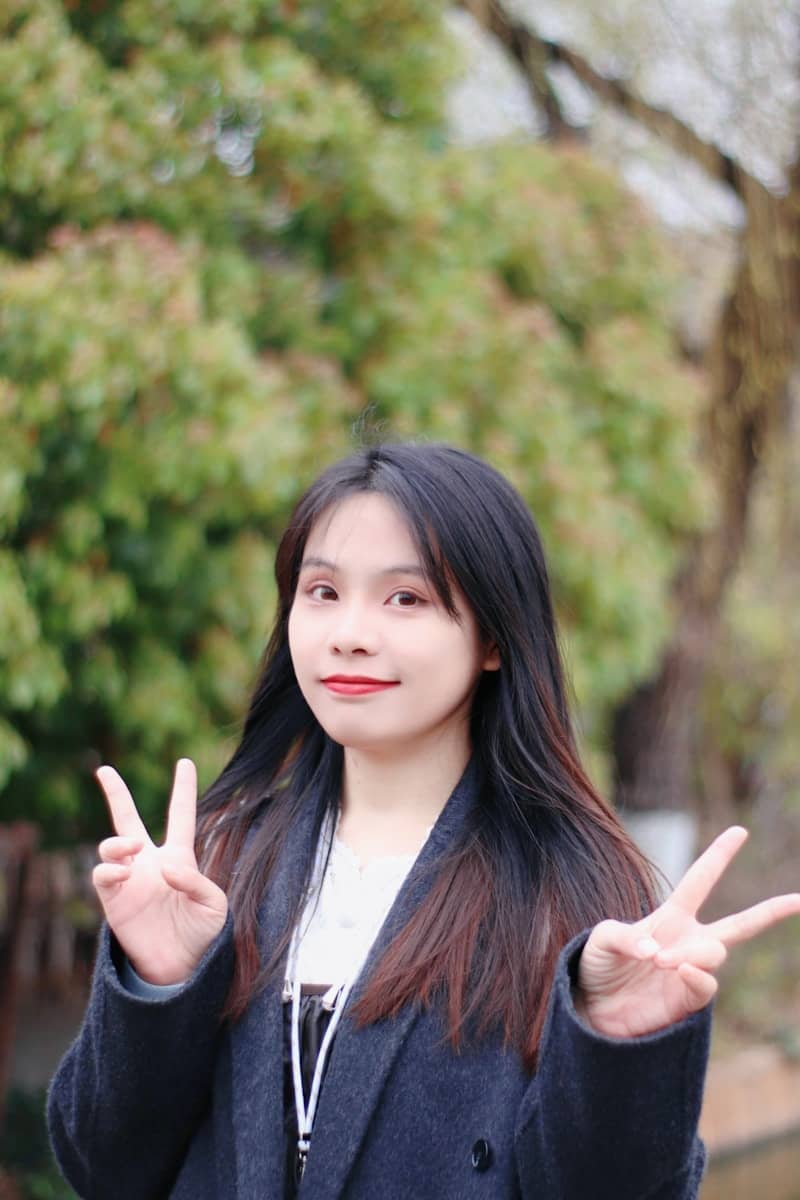 A smiling teen girl gives the peace sign.