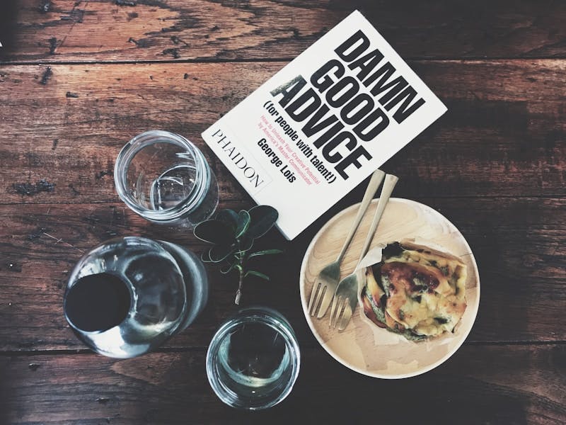 book on table with dishes and glasses