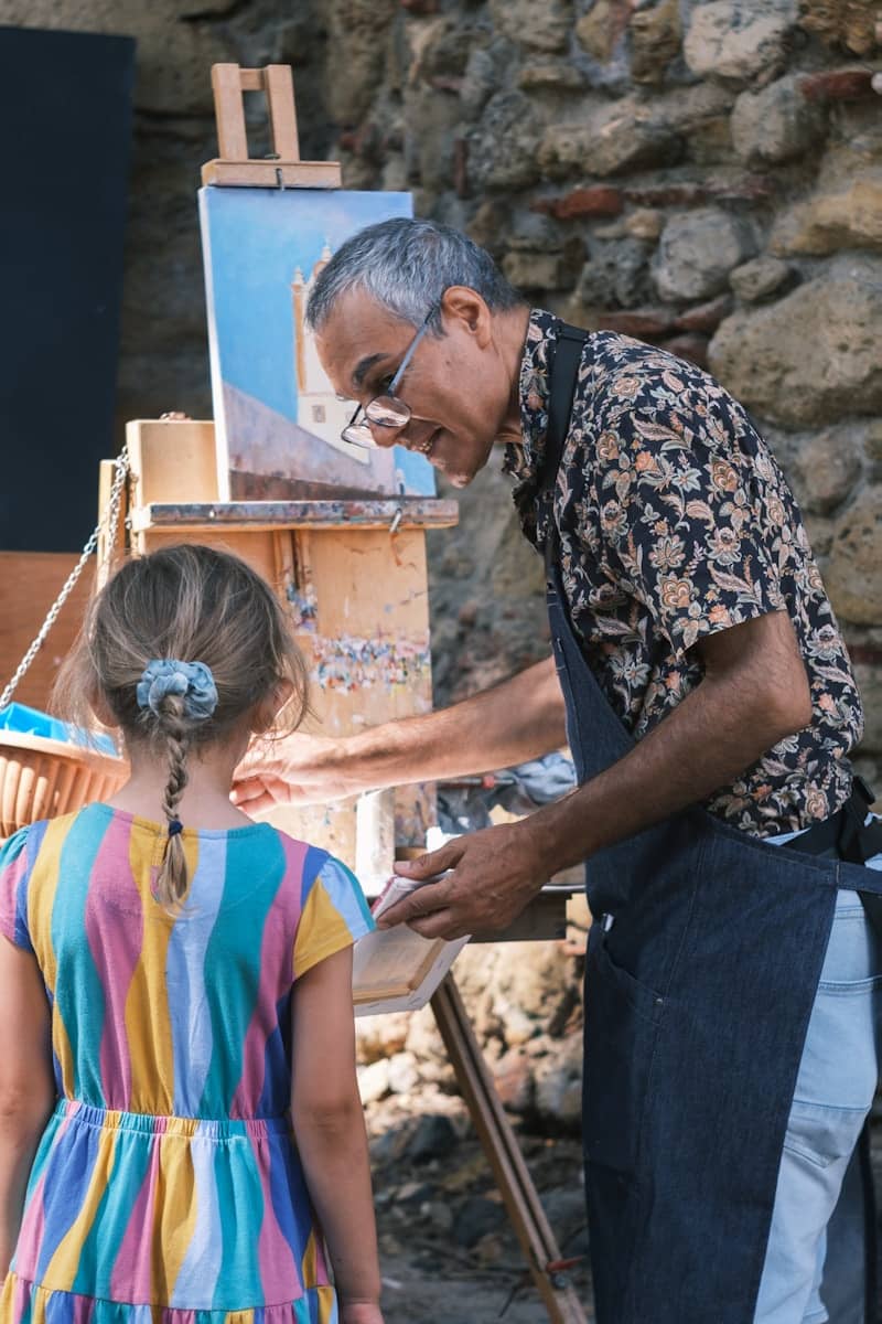 Artist teaching a child to paint outdoors