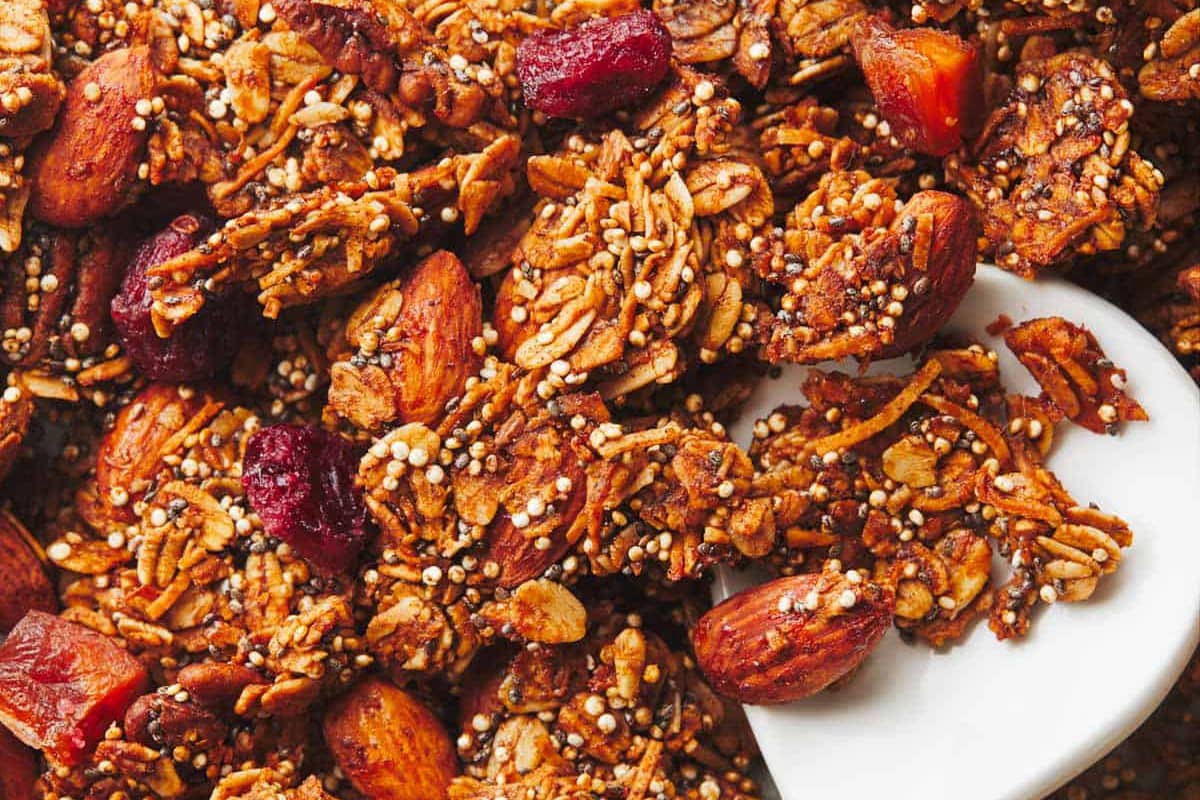 Maple Quinoa Granola on a sheet pan with a spoon