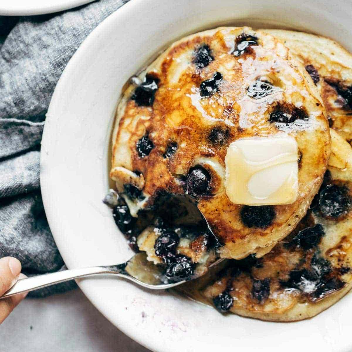 Blueberry pancakes with a pat of butter on a plate