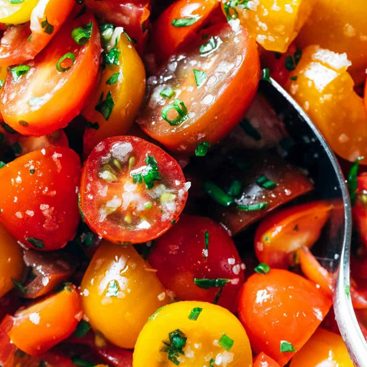 Close-up of marinated tomatoes with a spoon.