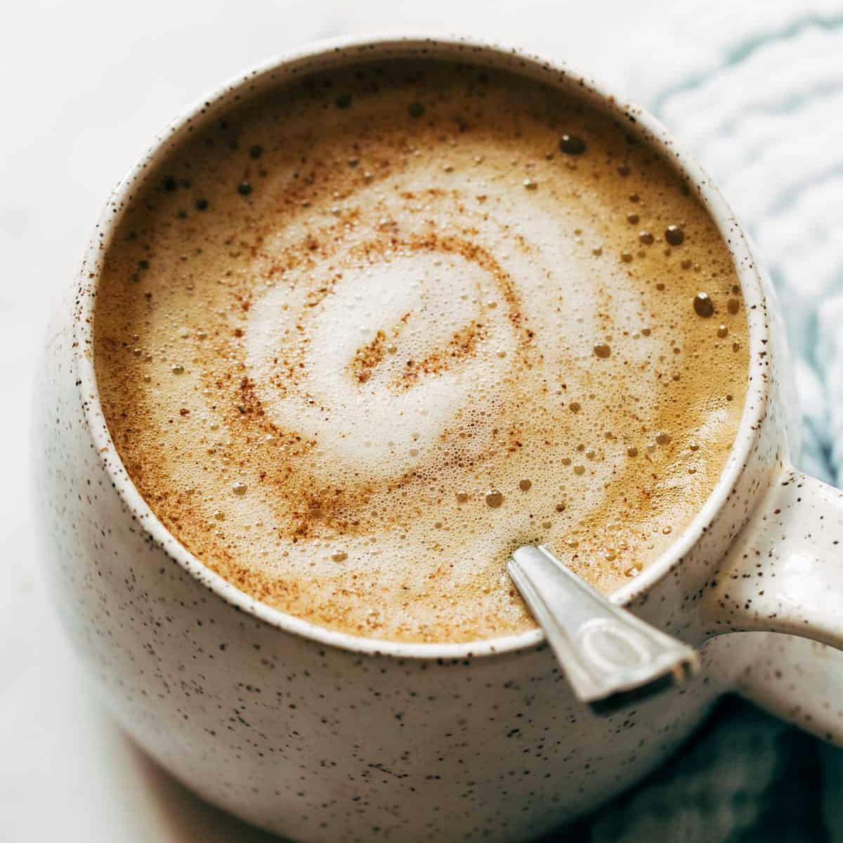 Oatmilk honey latte in a mug with a spoon