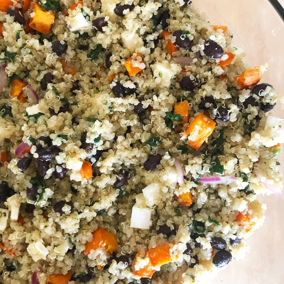 Couscous salad in a bowl with sweet potatoes and black beans.