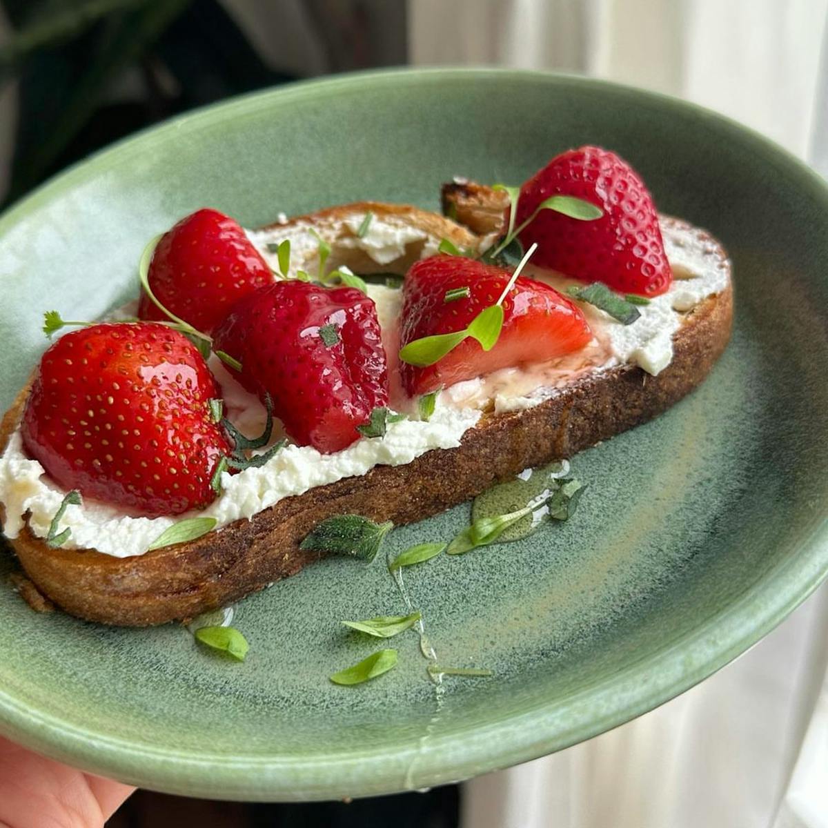 Pickled strawberries on toast with goat cheese