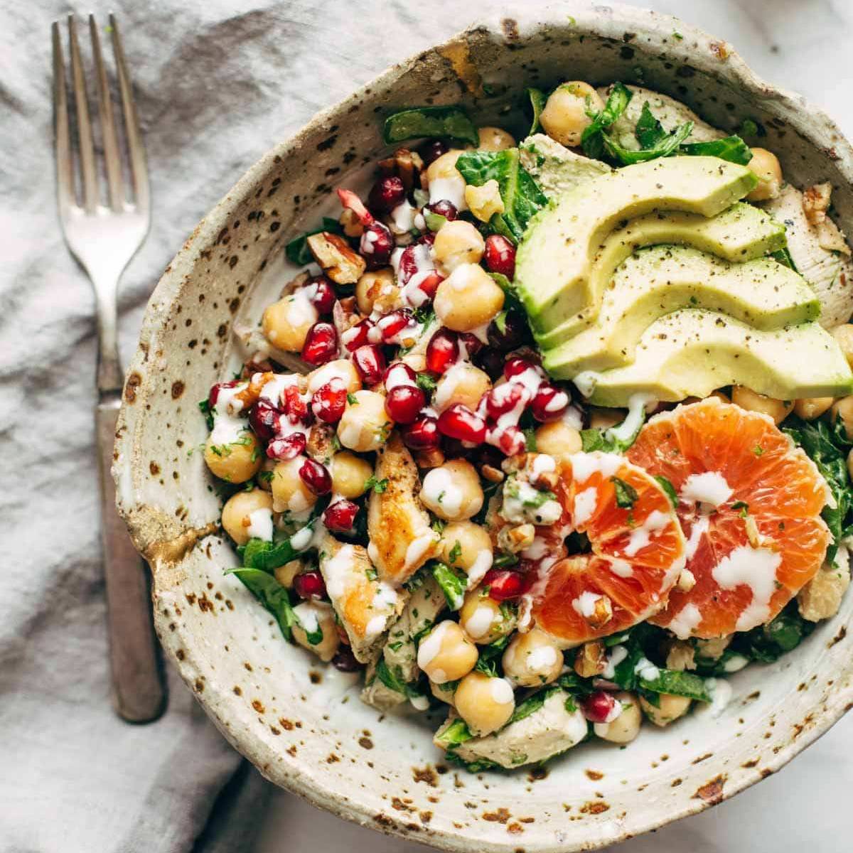 Winter spa salad with dressing drizzled on top and a fork on the side