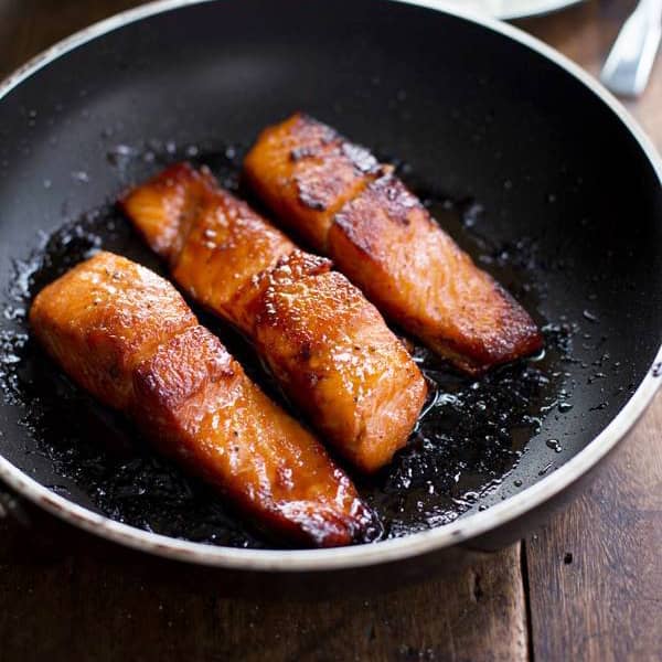 Caramelized salmon in a skillet.