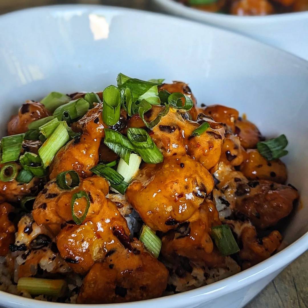 Chili crunch tofu in a bowl with rice and green onions