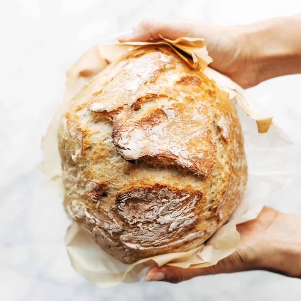 No knead bread held by two hands.
