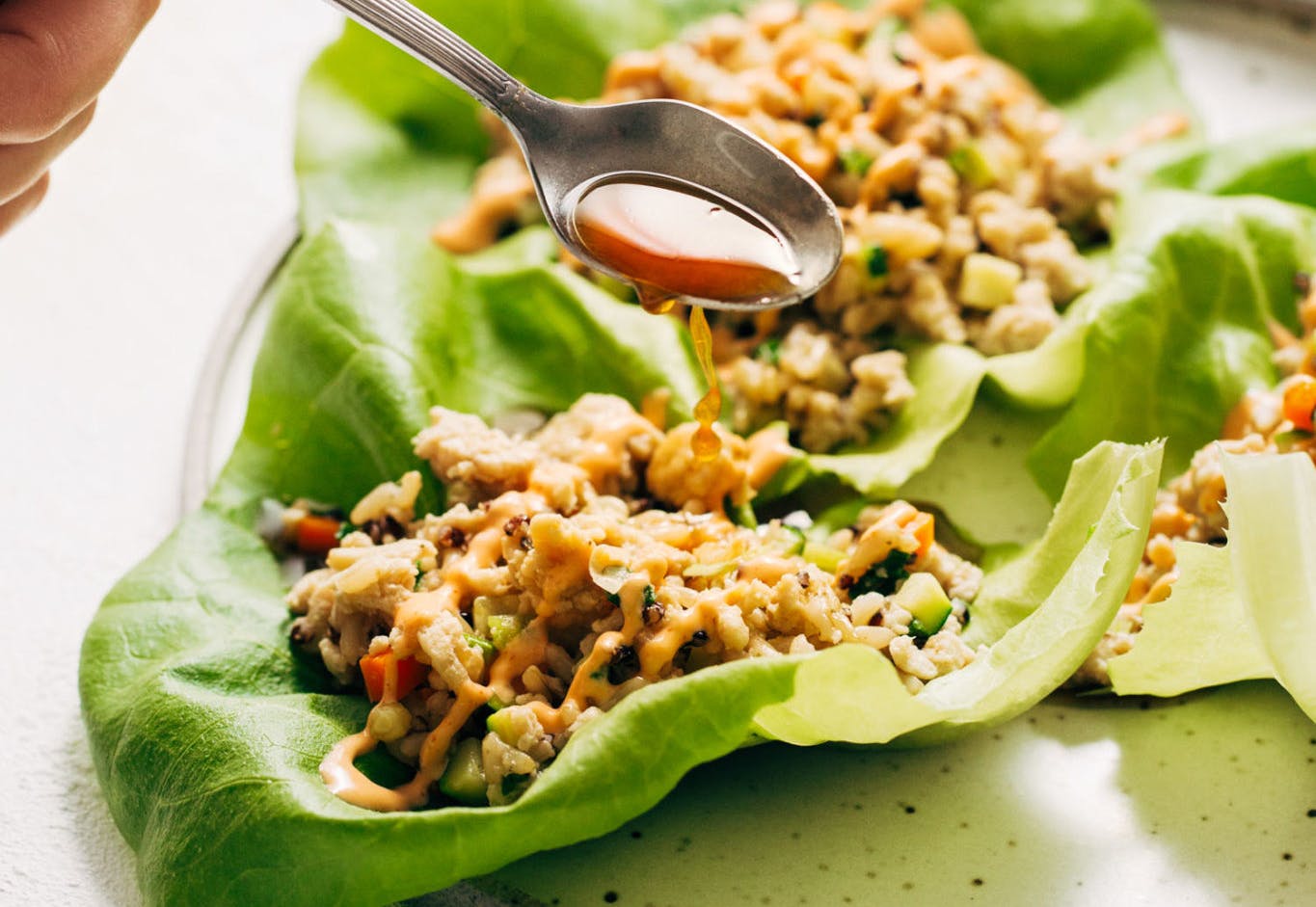 Lettuce wraps with filling and lime sauce drizzled on top