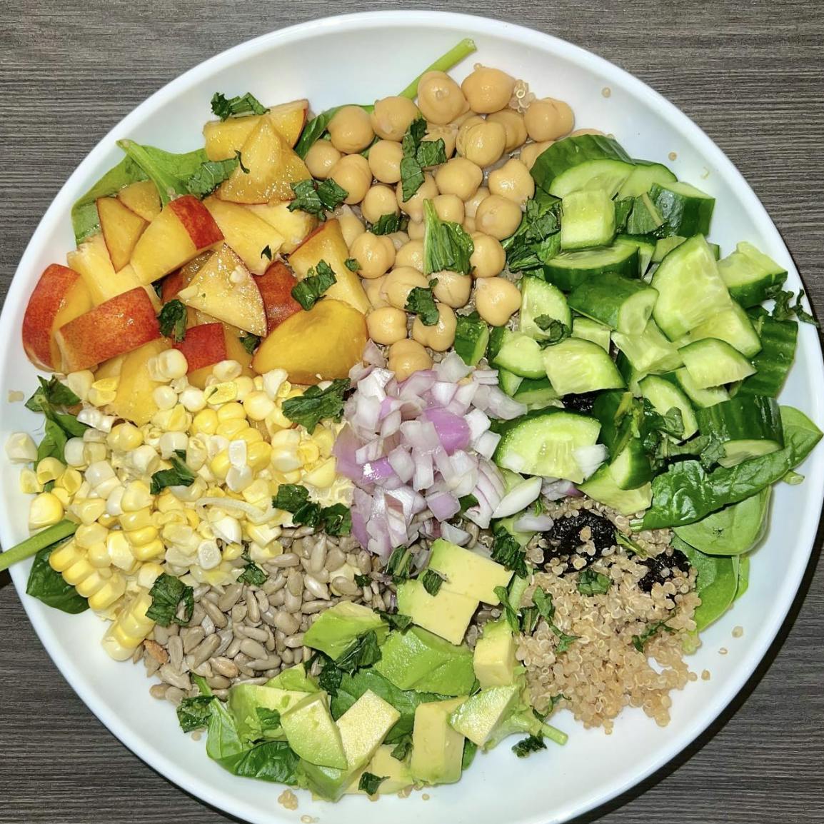 Bowl with couscous, fresh veggies, nectarines, and avocado.