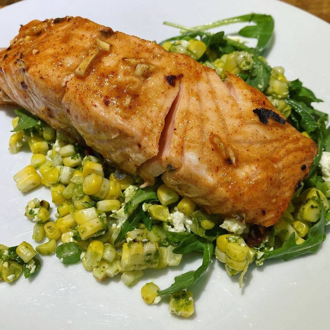 Honey salmon on a plate over a corn salad