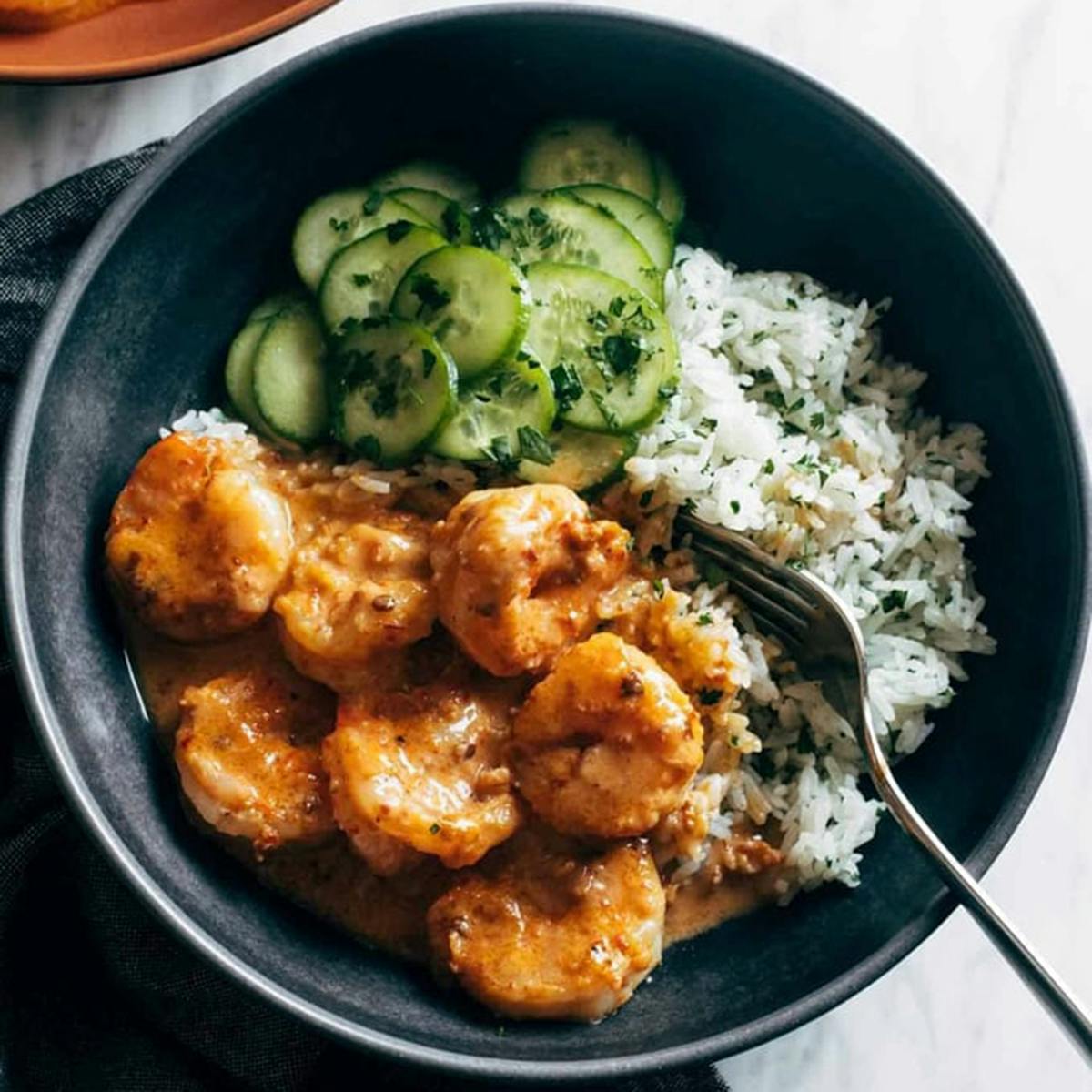 Chipotle shrimp in a bowl with rice and cucumbers