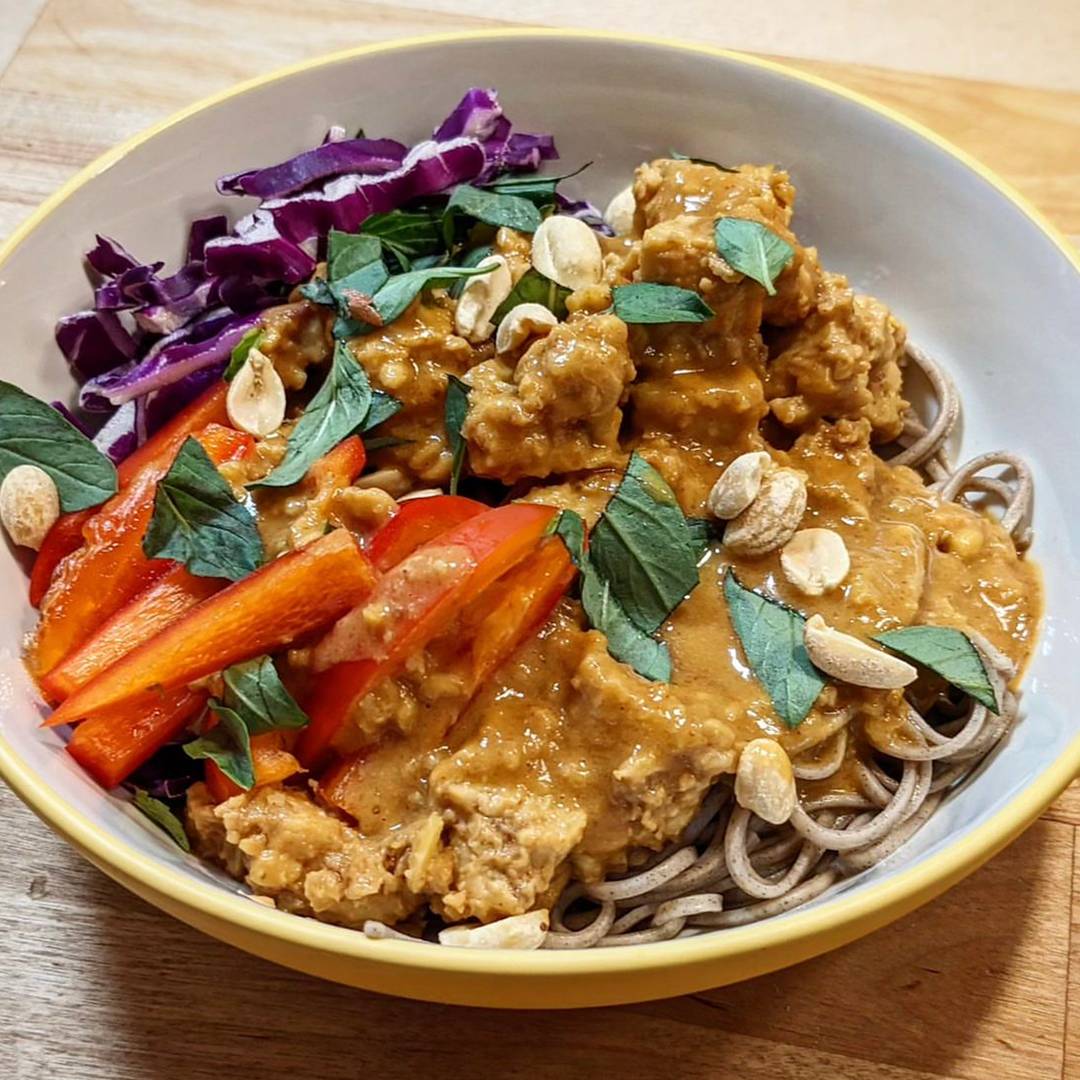 Spicy peanut soba noodle salad in a bowl with soba noodles, red bell peppers, cabbage, and cilantro