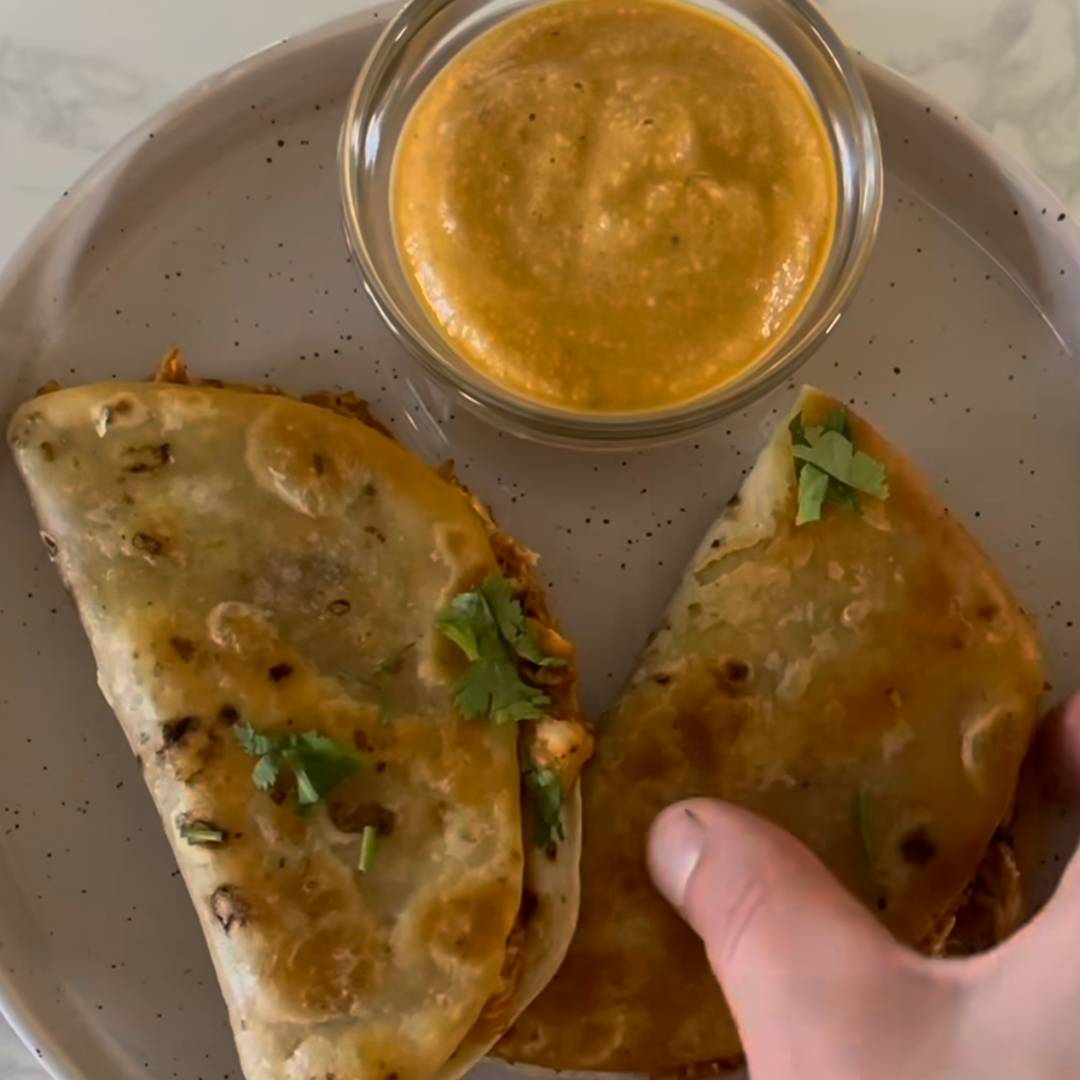 Tacos being dunked into chipotle cashew queso dip