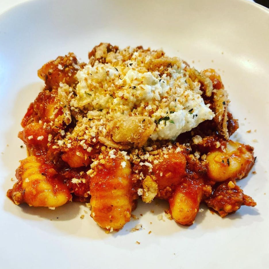 Gnocchi on a plate with ricotta and breadcrumbs.