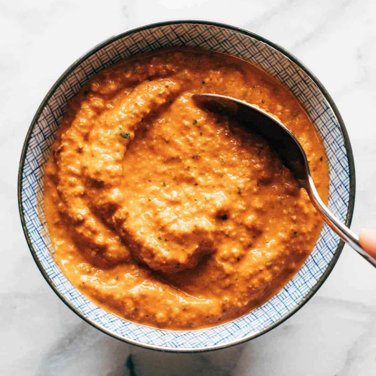 Blended romesco sauce in a bowl with a spoon.