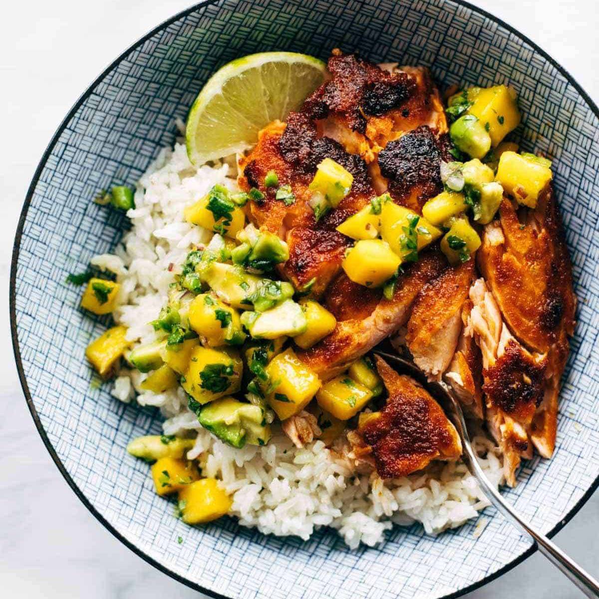 BBQ salmon in a bowl with rice and mango avocado salsa.