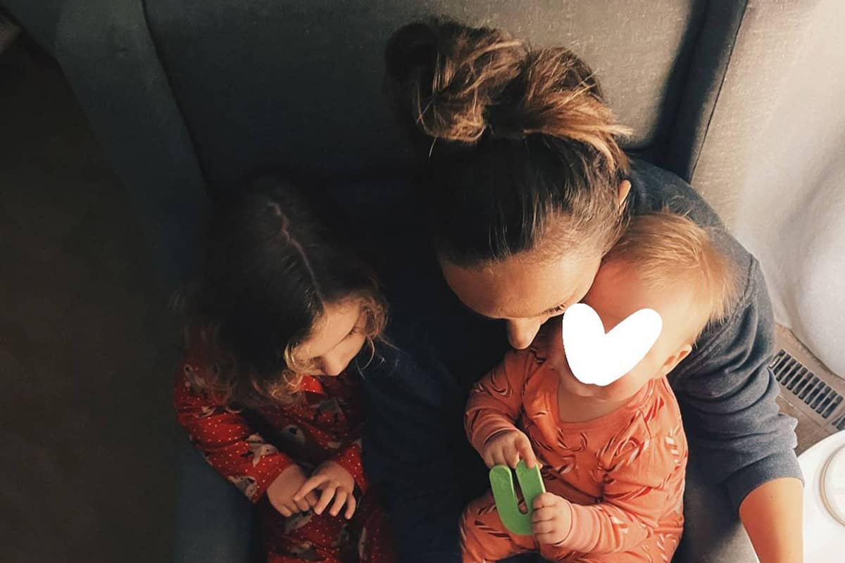 Woman reading to two babies sitting on her lap