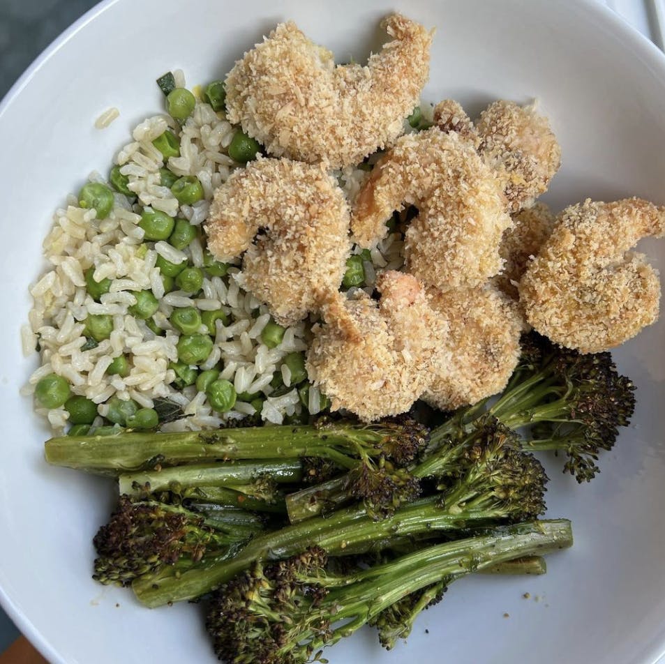 Baked coconut shrimp in a bowl with rice and veggies.