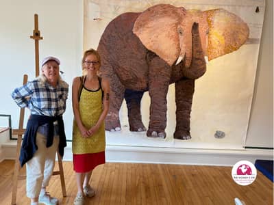 Publisher Pamela Burke with Visual Artist Lucky Platt with her Elephant Collage at Farnsworth Museum’s 365 Arts Gallery in Maine | Photo: P. Burke
