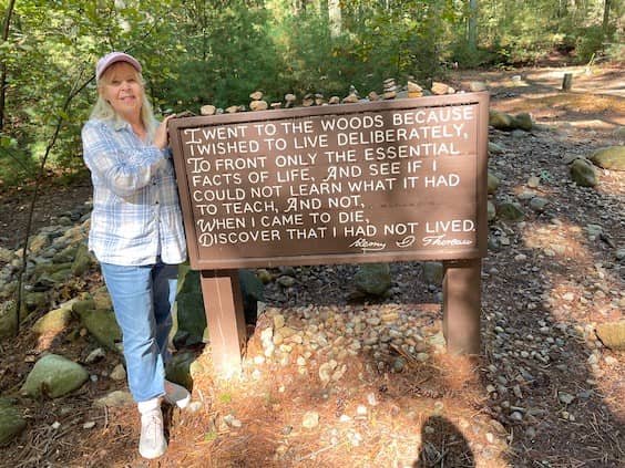 Pamela Burke at Walden Pond by wood sign with Henri Thoreau