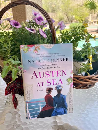 Photo of Natalie Jenner's book, Austen at Sea, against a backdrop of purple petunias | Photo: P Burke