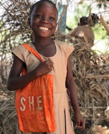 Fidele Soklou, 8-year-old primary school student, now 10 and in the 4th grade. Bag and unform made by SHE seamstresses.