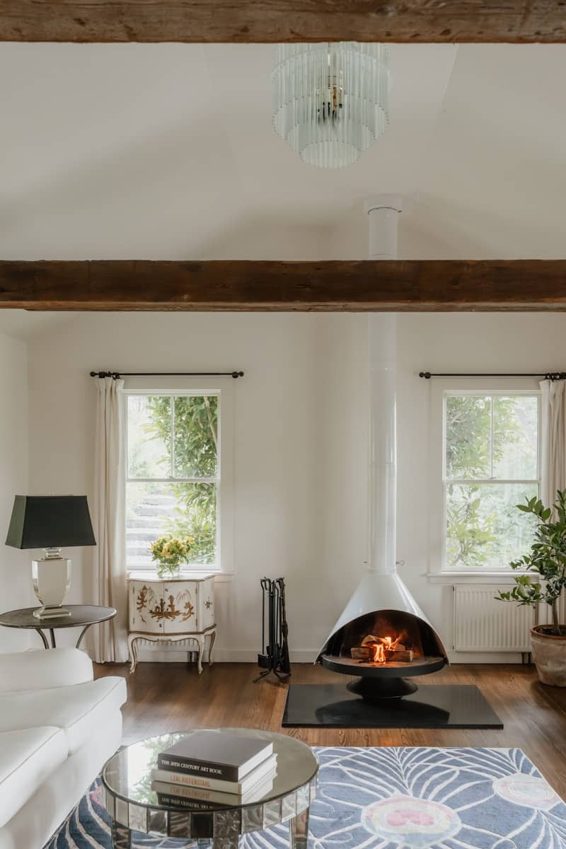 Modern living room with hanging fireplace and large windows.