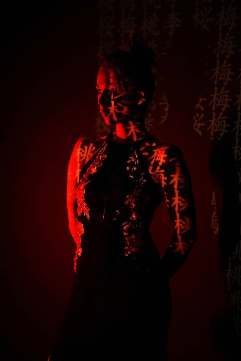 A woman in red with projected chinese characters.