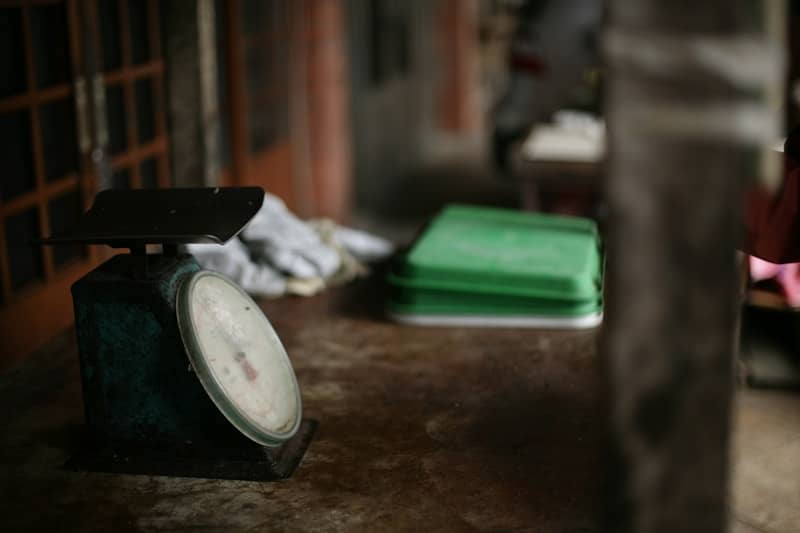 An old scale sits on a worn wooden surface.