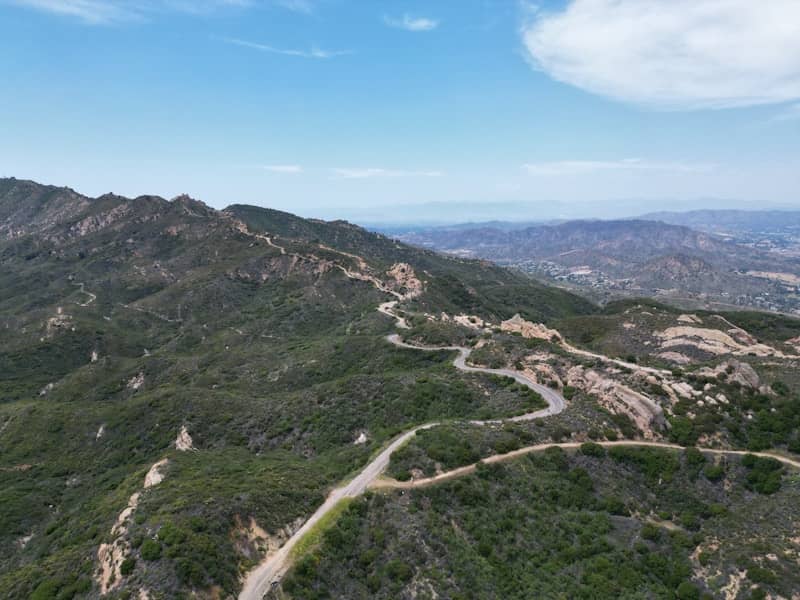 Winding road ascends through mountainous terrain.