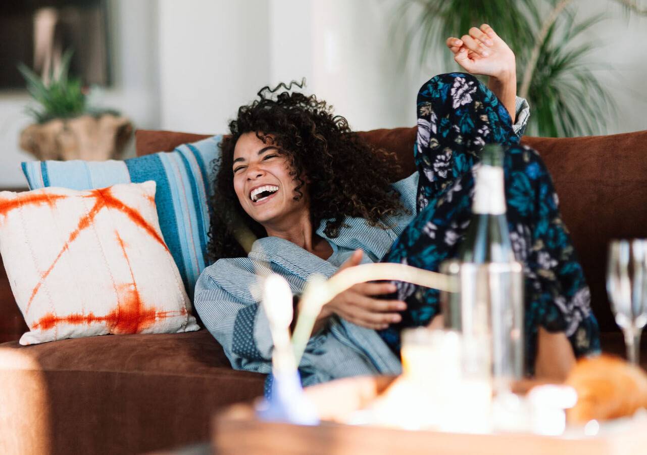 A little girl wearing a mask and holding balloons