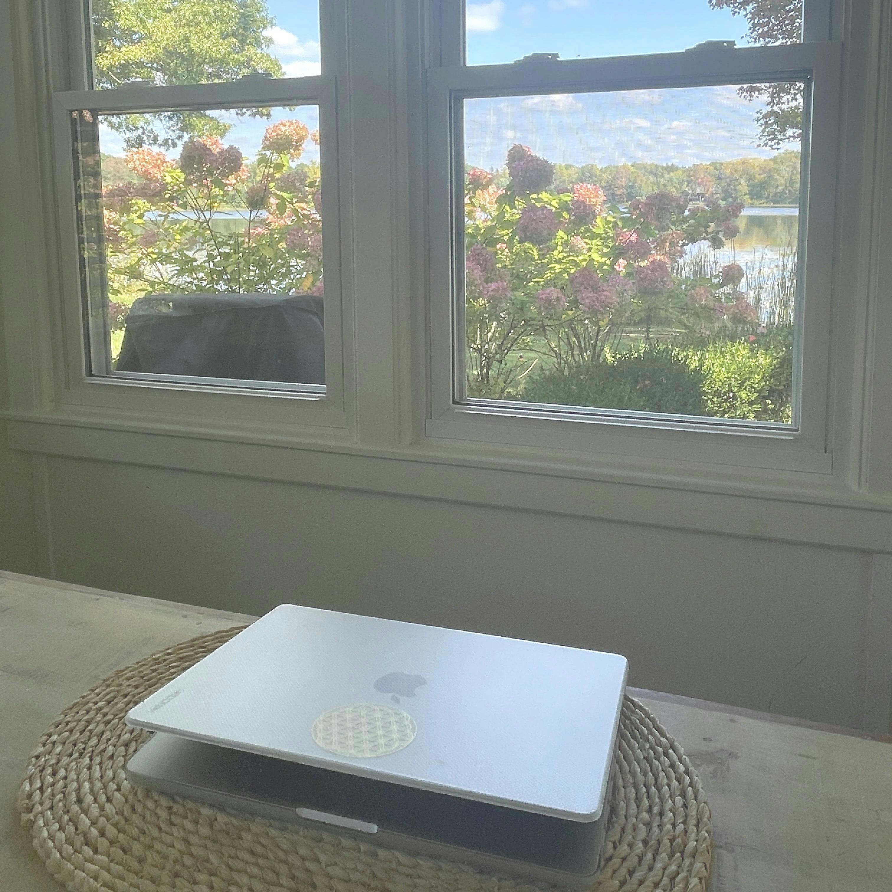 girl wearing grey long-sleeved shirt using MacBook Pro on brown wooden table