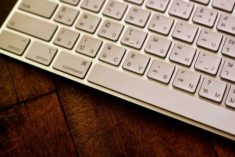 Keyboard sits on top of a wooden table.