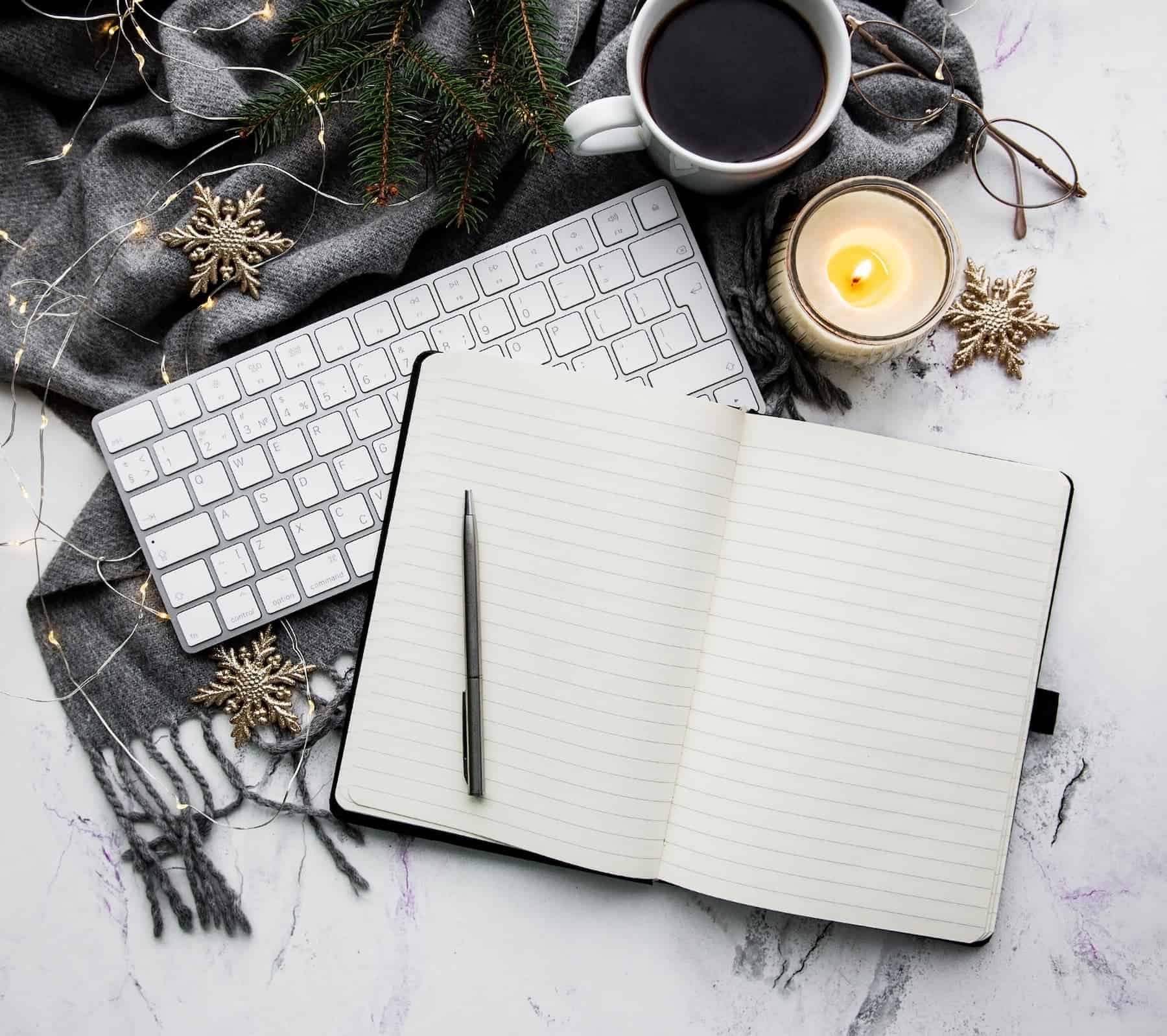 A tidy desk features a notebook for to-do lists and a warm cup of coffee — a calming scene that reflects practical Tips to Stay Organized.