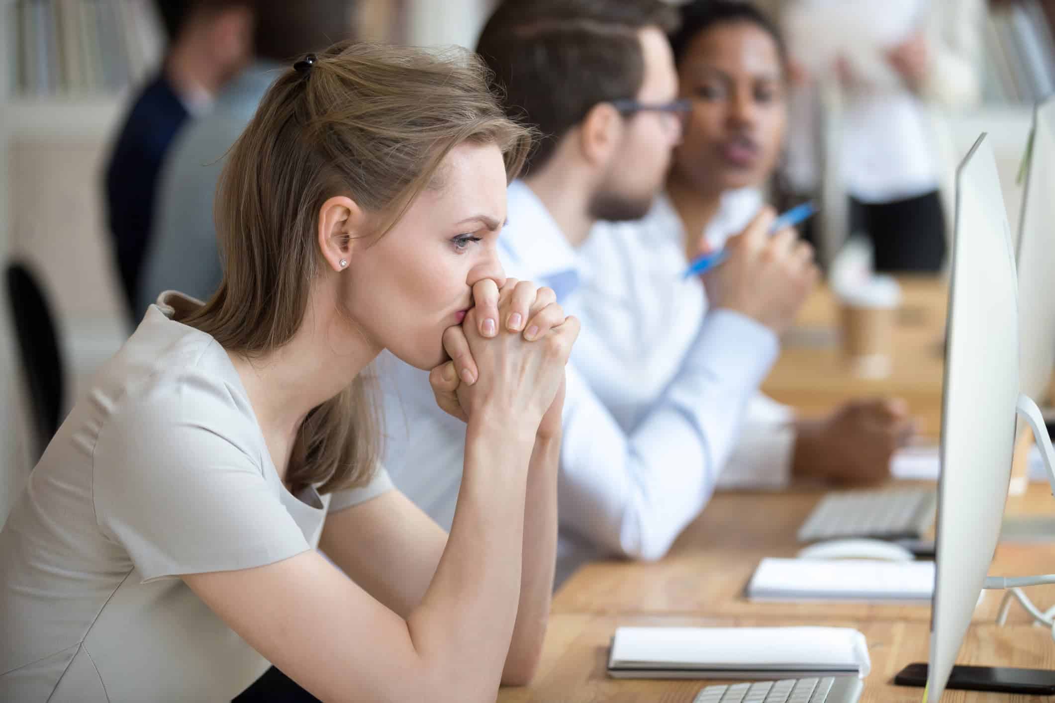Woman sitting at her desk, looking thoughtful and distant — a quiet moment of reflection that suggests she may be settling in life without realizing it.