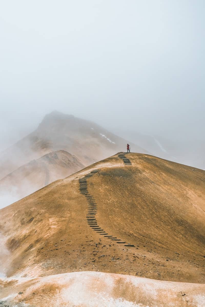 man on top brown hill