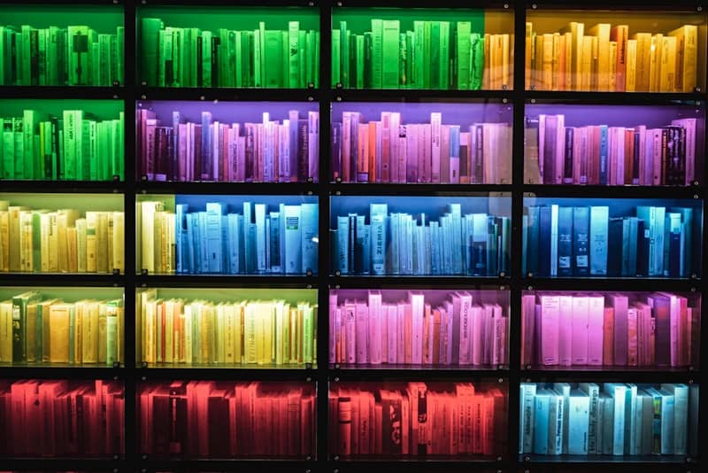 A book shelf filled with lots of different colored books