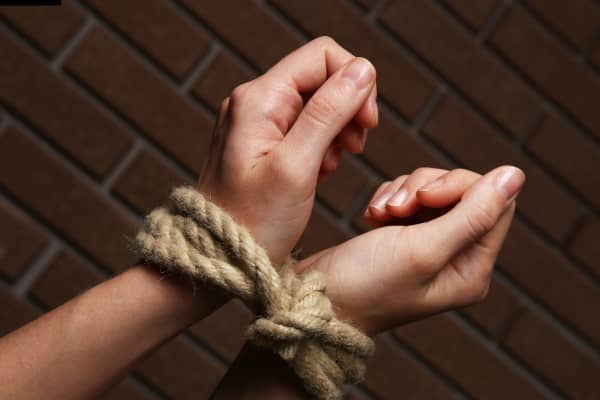 Hands tied together with rope.