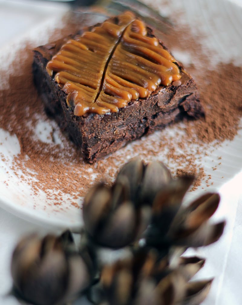 a white plate topped with a piece of chocolate cake