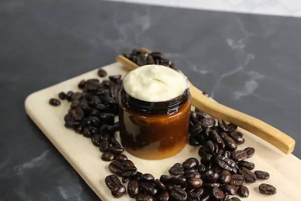 a jar of homemade coffee eye cream with coffee beans